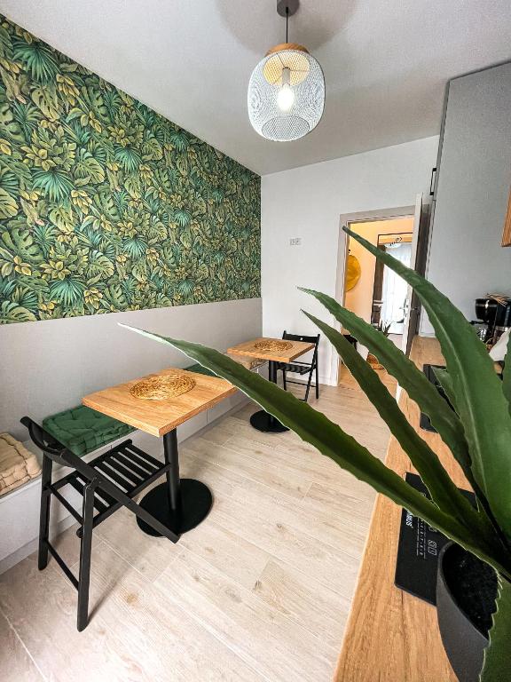 um quarto com duas mesas e um vaso de plantas em Casa Nis - Apartament 2 dormitoare in Sibiu em Turnişor