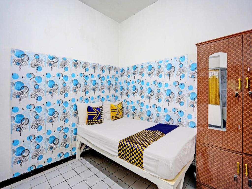 1 dormitorio con 1 cama y una pared azul y blanca en SPOT ON 92652 Meir E-homestay 2 Syariah, en Surabaya