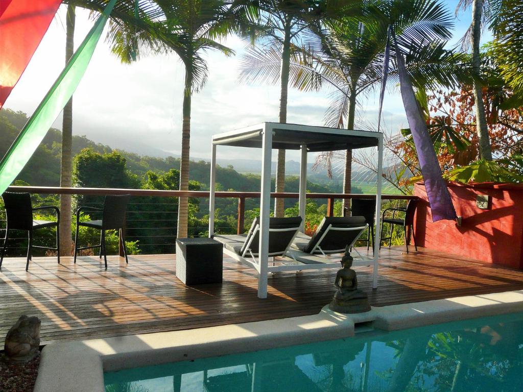 a deck with chairs next to a swimming pool at Mai Tai Resort in Cassowary