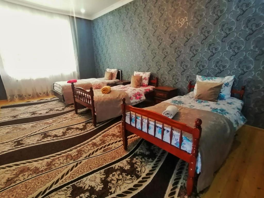 sypialnia z 2 łóżkami i kanapą w obiekcie Fairy house w mieście Qəbələ