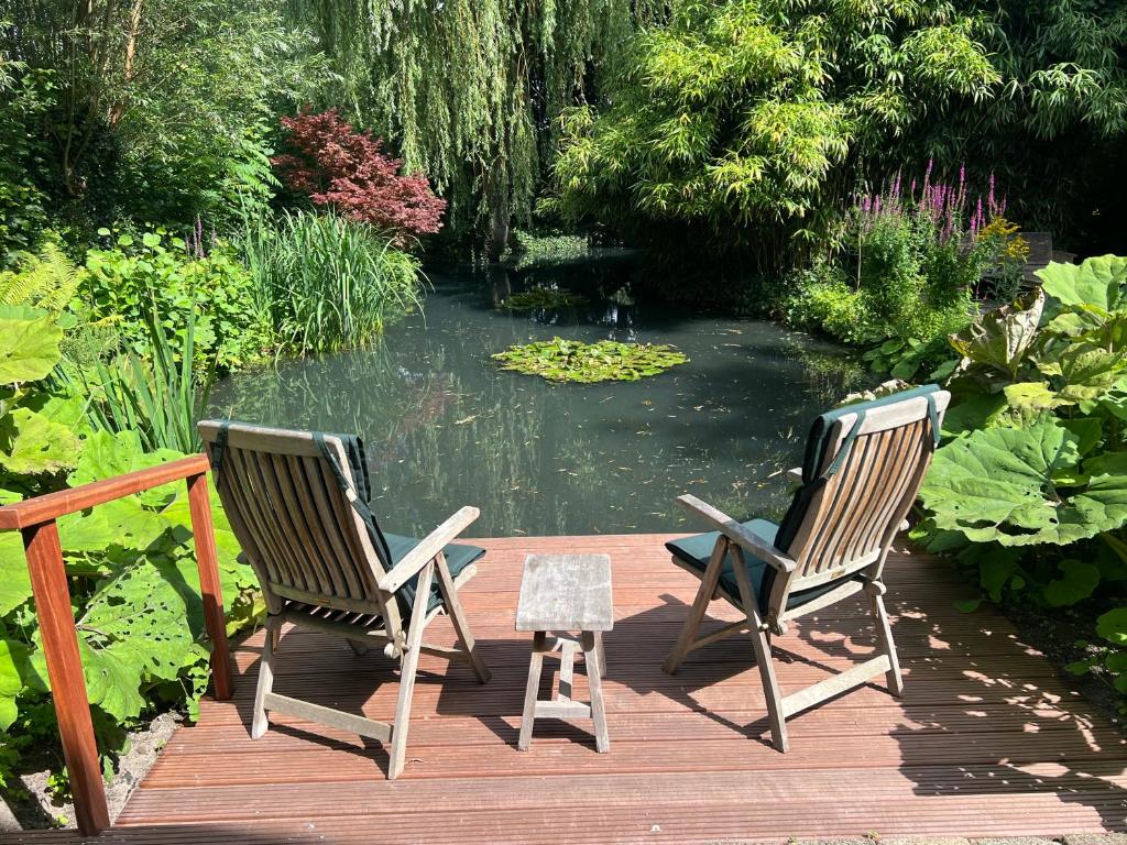 twee stoelen op een terras bij een vijver bij B&B Lekkerkerk in Lekkerkerk