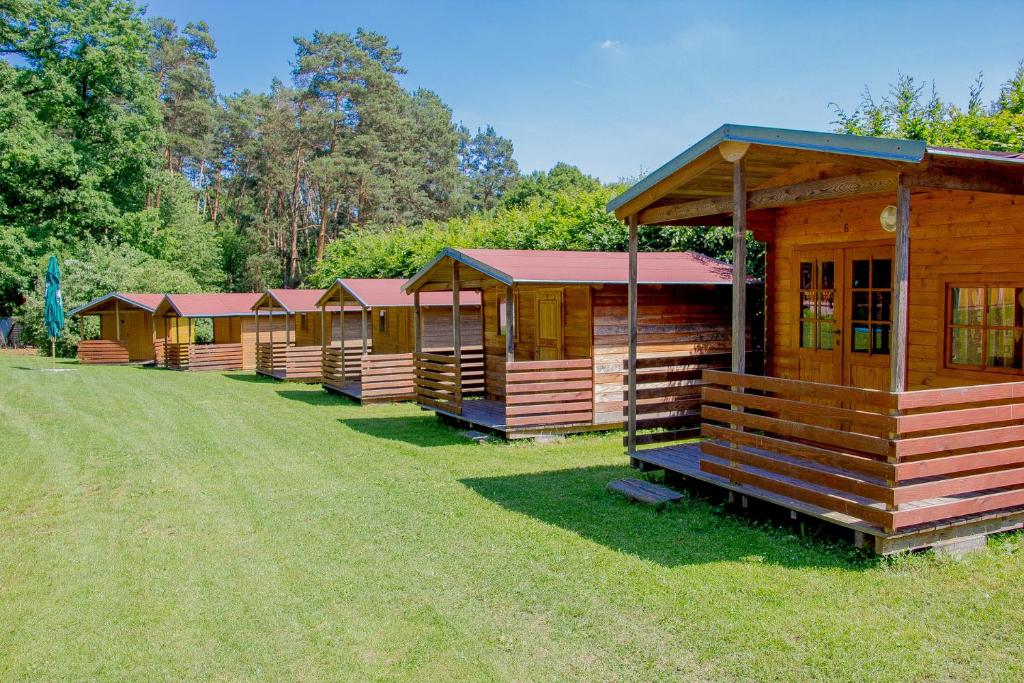 a row of wooden cabins are lined up in the grass at ASTRA Lančov in Lančov