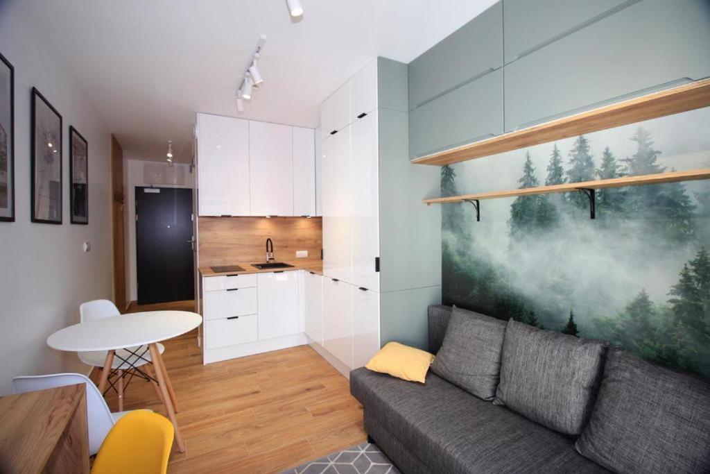 a living room with a couch and a kitchen at Mikro Aparty bezpłatny parking in Wrocław