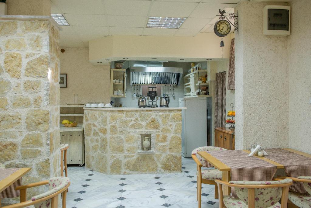 a kitchen with a table and a stone fireplace at Hotel Villa Perla Di Mare in Budva
