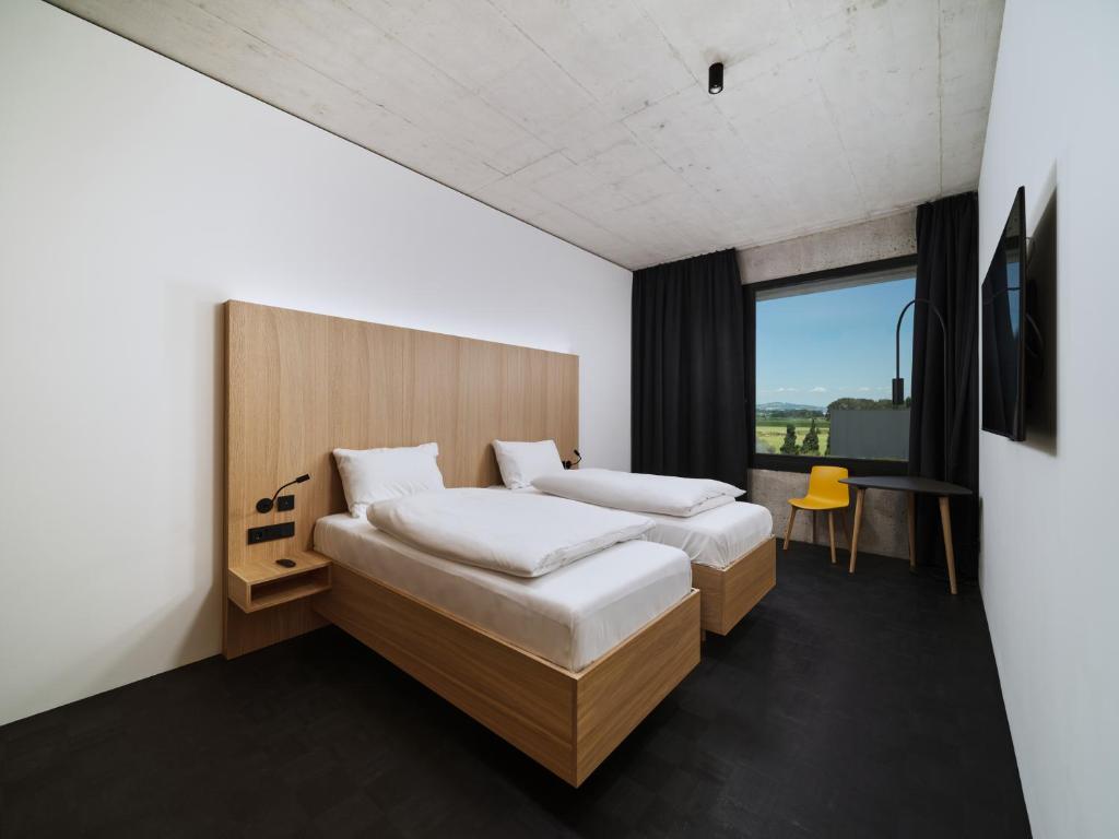 um quarto de hotel com duas camas e uma janela em Boulderbar Hotel Leonding em Linz