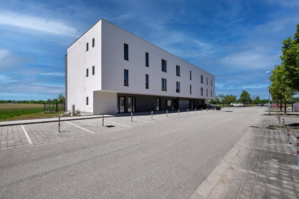 duży biały budynek z parkingiem w obiekcie RELAX PARK Třeboň II w Trzeboniu