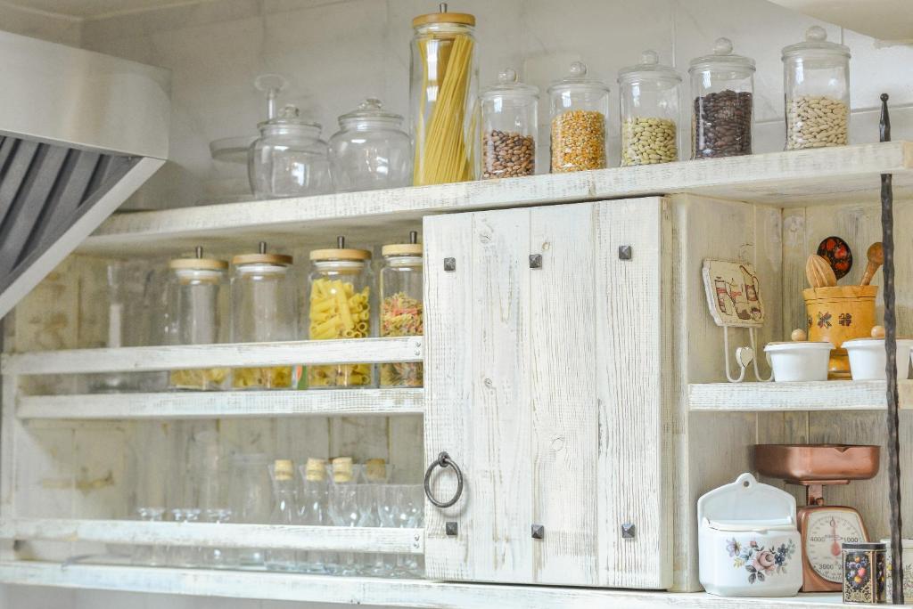 a cabinet filled with lots of glass jars at Hotel Villa Perla Di Mare in Budva
