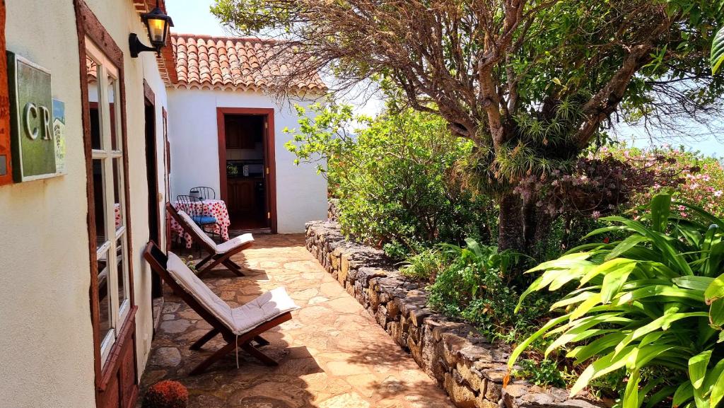 a patio with two benches in front of a house at El Jócamo in Puntagorda