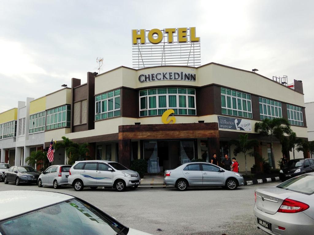 a hotel with cars parked in front of it at Hotel Checkedinn in Ipoh