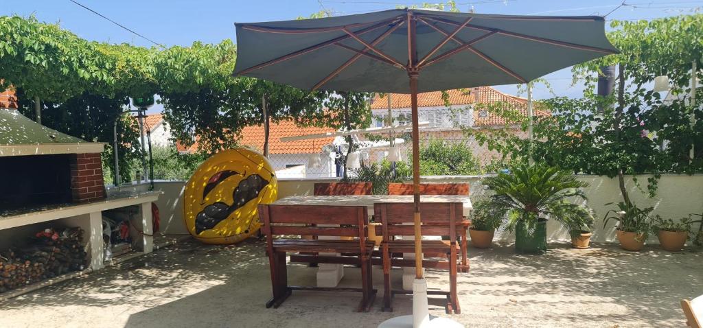 een tafel met een parasol op een patio bij Guesthouse Lidija in Sutivan