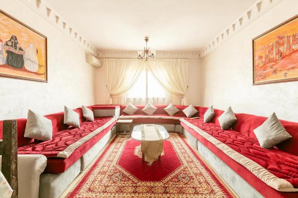 una sala de estar con sofás rojos y una ventana en Appartement spacieux Centre Marrakech, en Marrakech