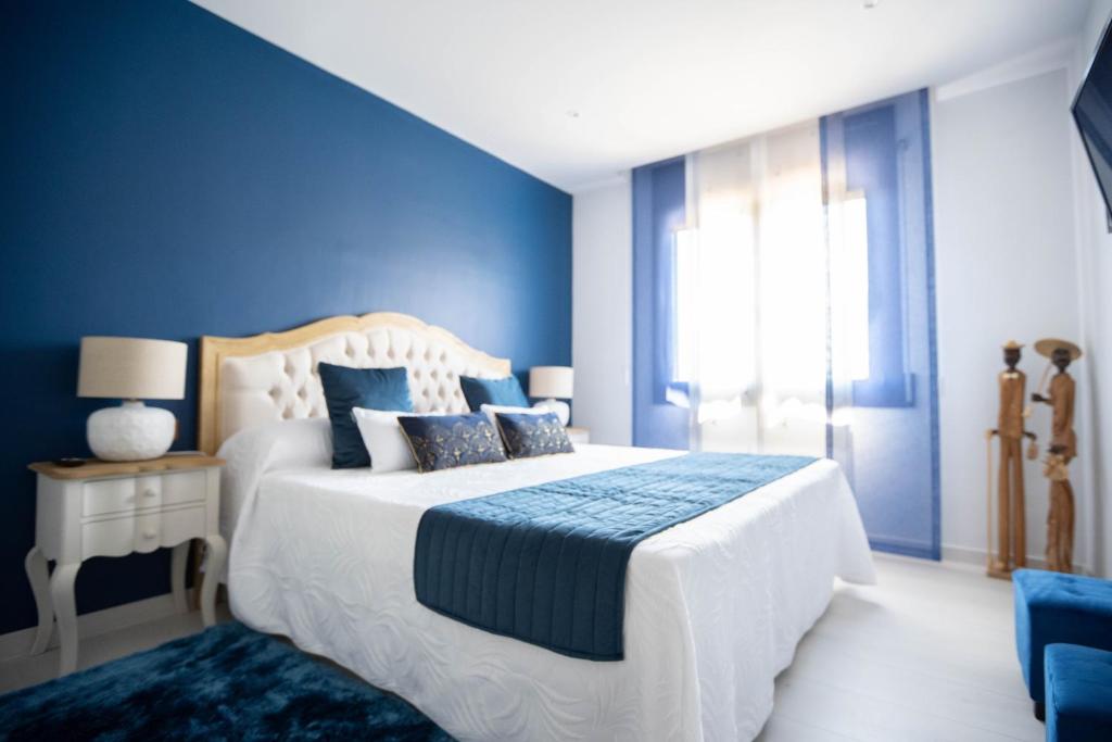 een blauwe slaapkamer met een bed en een raam bij El Molí de Pontons suites con jacuzzi spa in Pontons