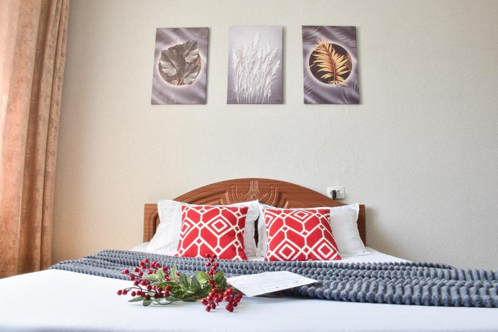 een slaapkamer met een bed met vier foto's aan de muur bij YourHouse Микрорайон Жетысу-2, дом 69 in Alma-Ata