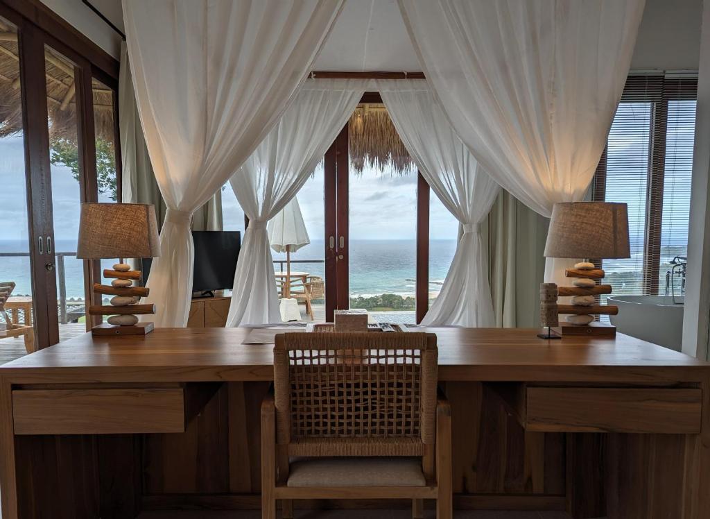 a home office with a desk with a view of the ocean at Umarato Villa Sumba in Rua