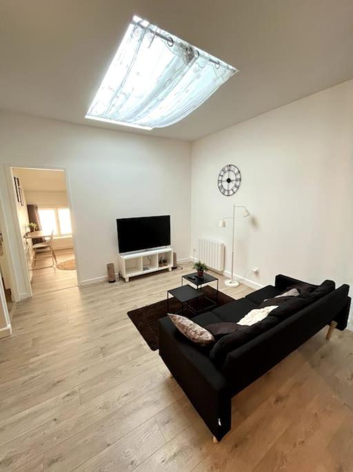 - un salon avec un canapé noir et un réveil dans l'établissement Luna - Moon 201 - Romans, à Romans-sur-Isère