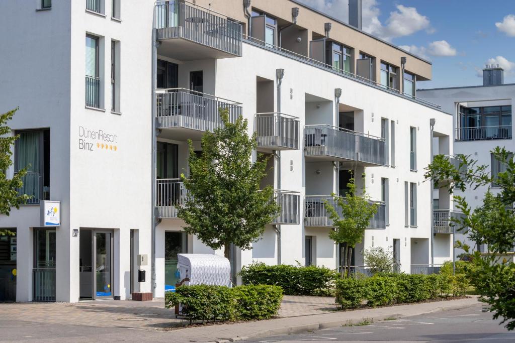 ein Mehrfamilienhaus mit Balkonen an einer Straße in der Unterkunft DünenResort Binz DünenResort Binz 125 in Binz