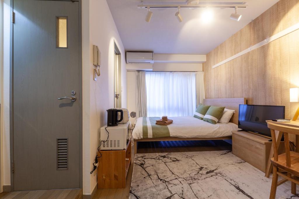 a small bedroom with a bed and a television at REJ Reflet Ebisu in Tokyo