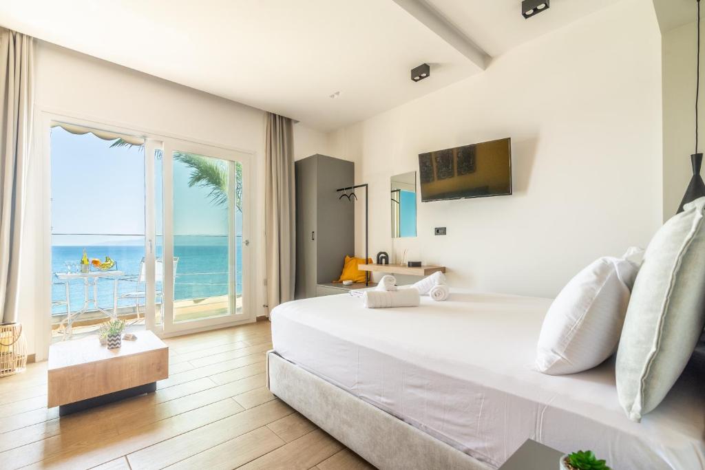 a bedroom with a large bed with a view of the ocean at Luxury SeaSide Suites in Hersonissos