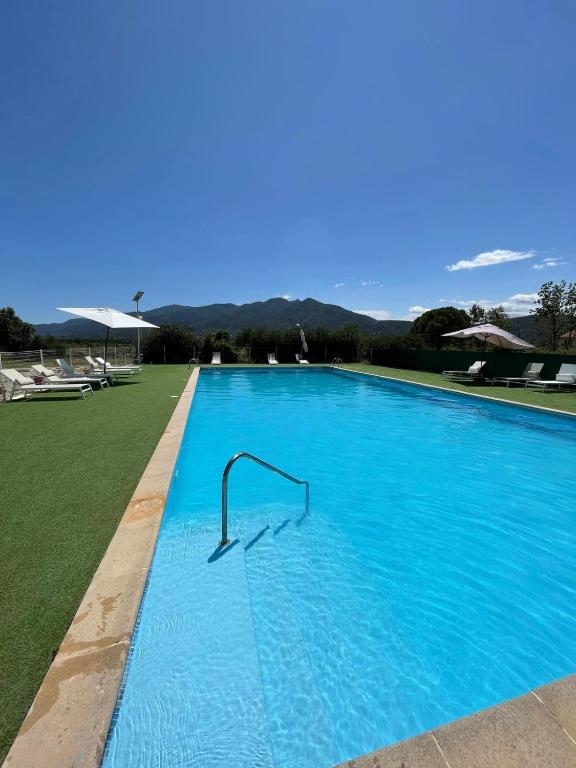 une grande piscine bleue avec un rail dans l'établissement HOTEL LA GARENNE, à Tresserre