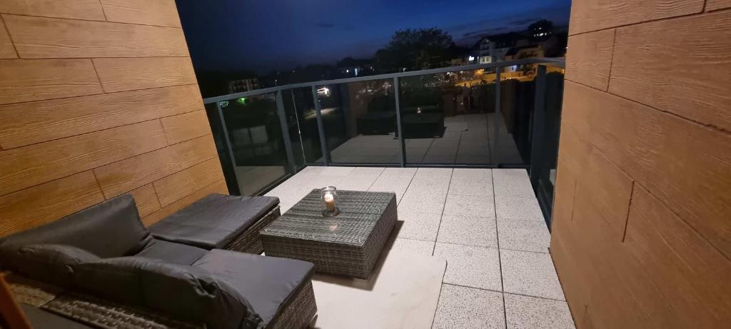 - Balcón con sofá y mesa en un edificio en Bel Mare Invest - free parking, en Międzyzdroje