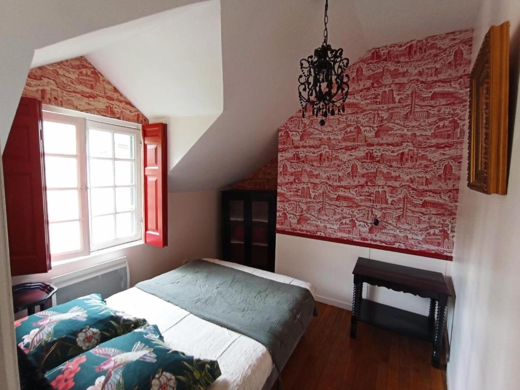 a bedroom with a bed and a red brick wall at A Vol D'Oiseau in Honfleur