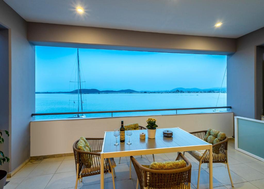 jadalnia ze stołem i krzesłami oraz dużym oknem w obiekcie Oikia Preveza seaview w Prewezie