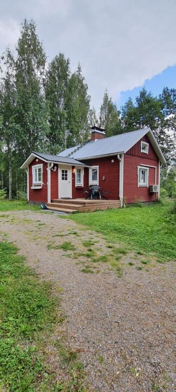 una casa rossa con un grande cortile di fronte di Jämsän Himoksen torppa Savusaunalla a Jämsä