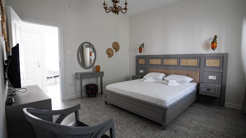sypialnia z łóżkiem, lustrem i krzesłem w obiekcie Büyükada Ece Suit w mieście Adalar