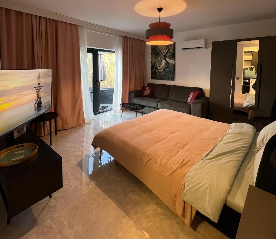 Marina Beach Suites - Yalikavak في بودروم: غرفة نوم بسرير كبير وغرفة معيشة