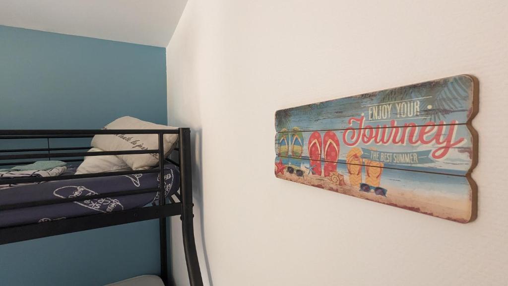 a sign hanging on a wall next to a bunk bed at Andernos-Maison de centre-ville avec jardin in Andernos-les-Bains