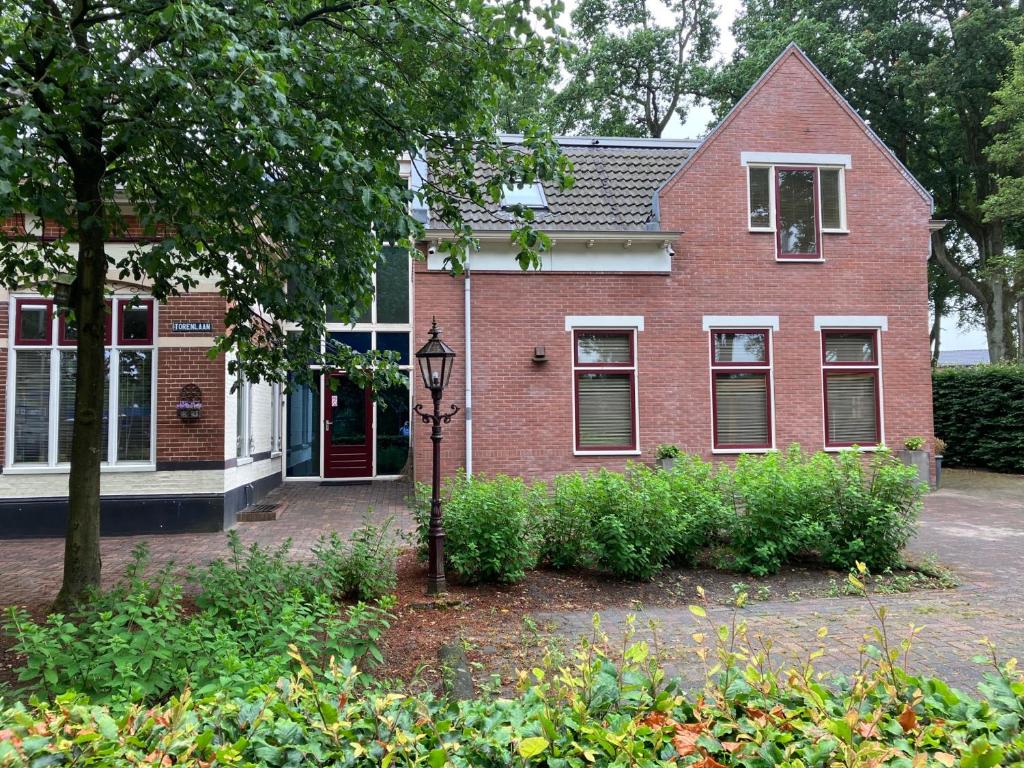 une maison en briques rouges avec un éclairage de rue devant elle dans l'établissement Borger appartement in centrum dorp., à Borger