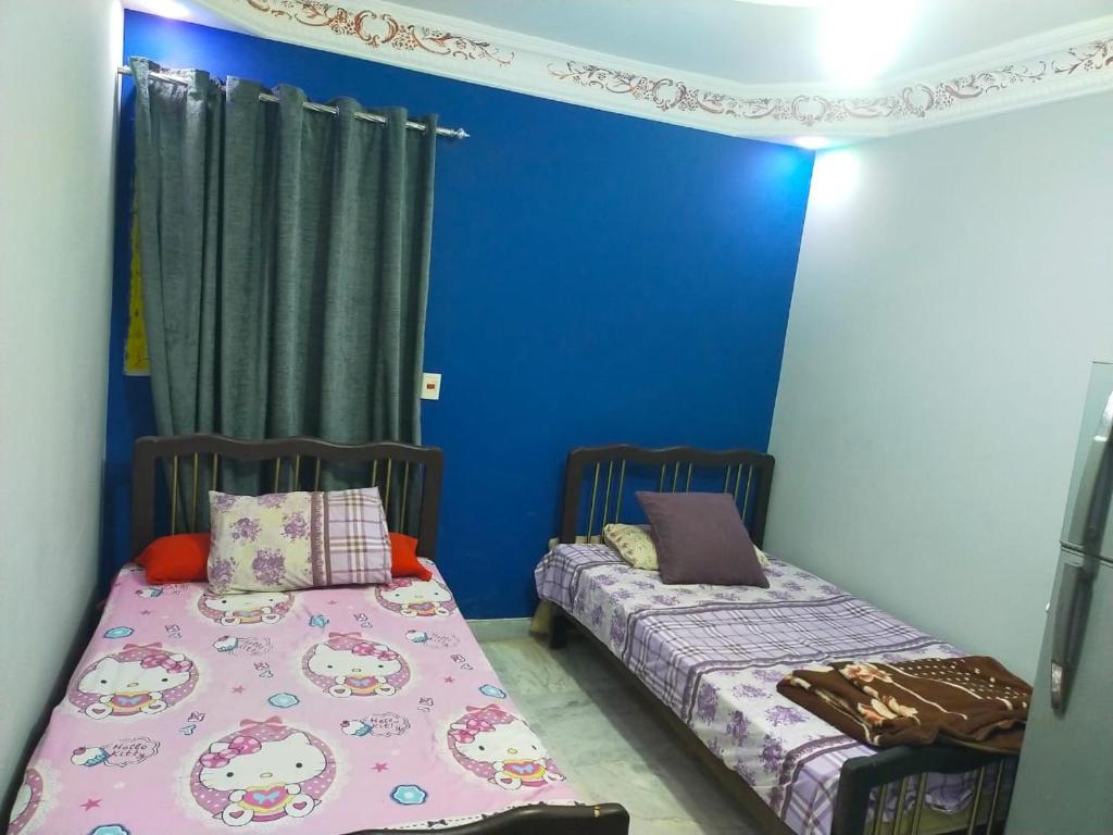 2 camas en una habitación con paredes azules en شقه فندقيه, en El Cairo