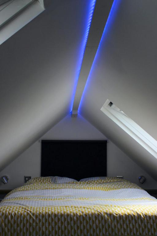 a bed in a room with a blue light at The Bubble Hideaway - A Little Oasis near the Sea in Whitstable