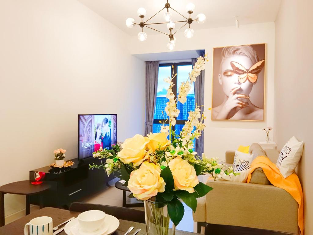 ein Wohnzimmer mit einer Vase aus gelben Rosen in der Unterkunft Medini Elysia Park , 3 min to Legoland, Netflix By Hint Homestay in Nusajaya