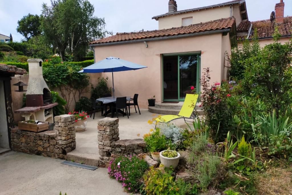 a patio with a table and an umbrella at Gîte Léperon 2 in Clisson