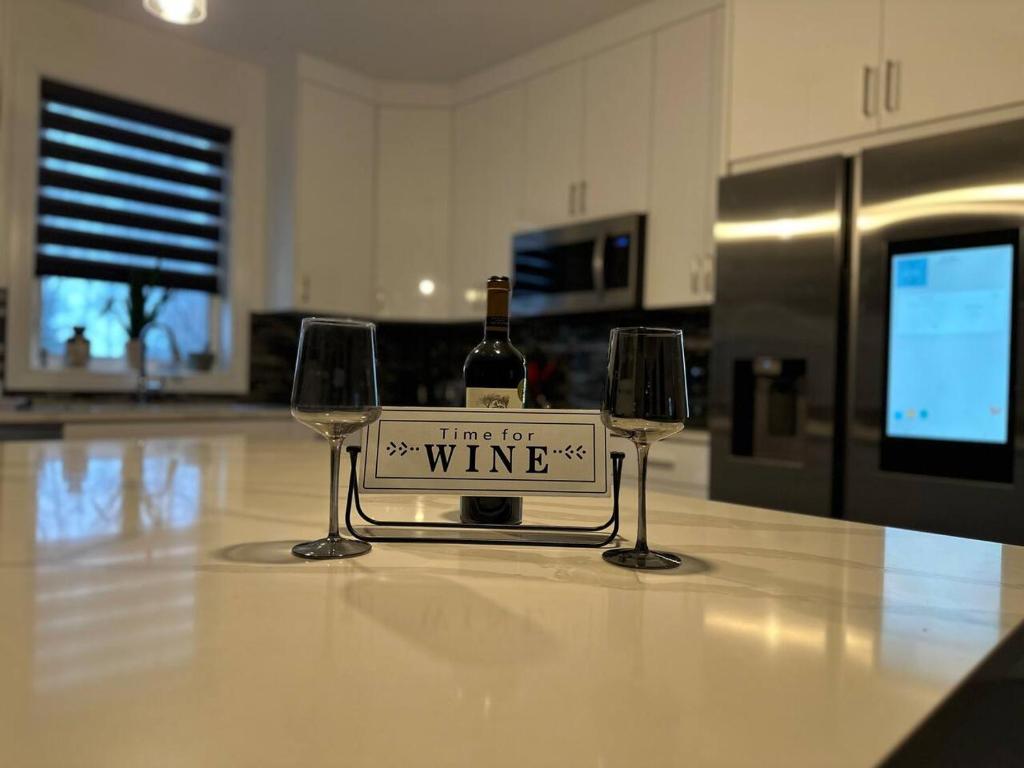 a bottle of wine sitting between two wine glasses at Headlands Airbnb in Rockport