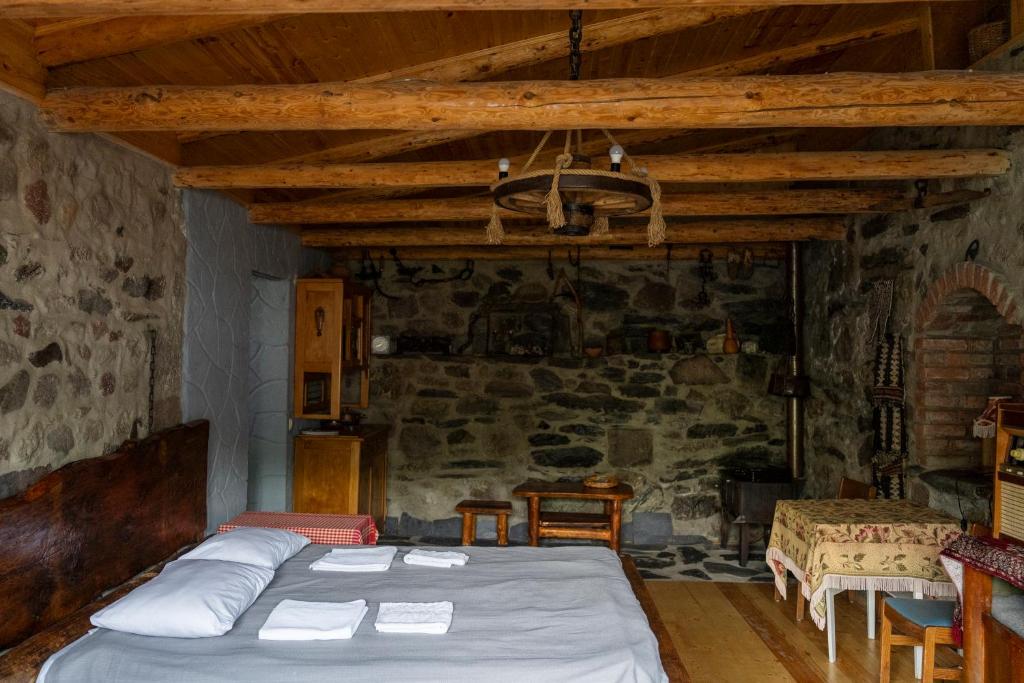 a bedroom with a bed and a stone wall at Kohi in Kazbegi