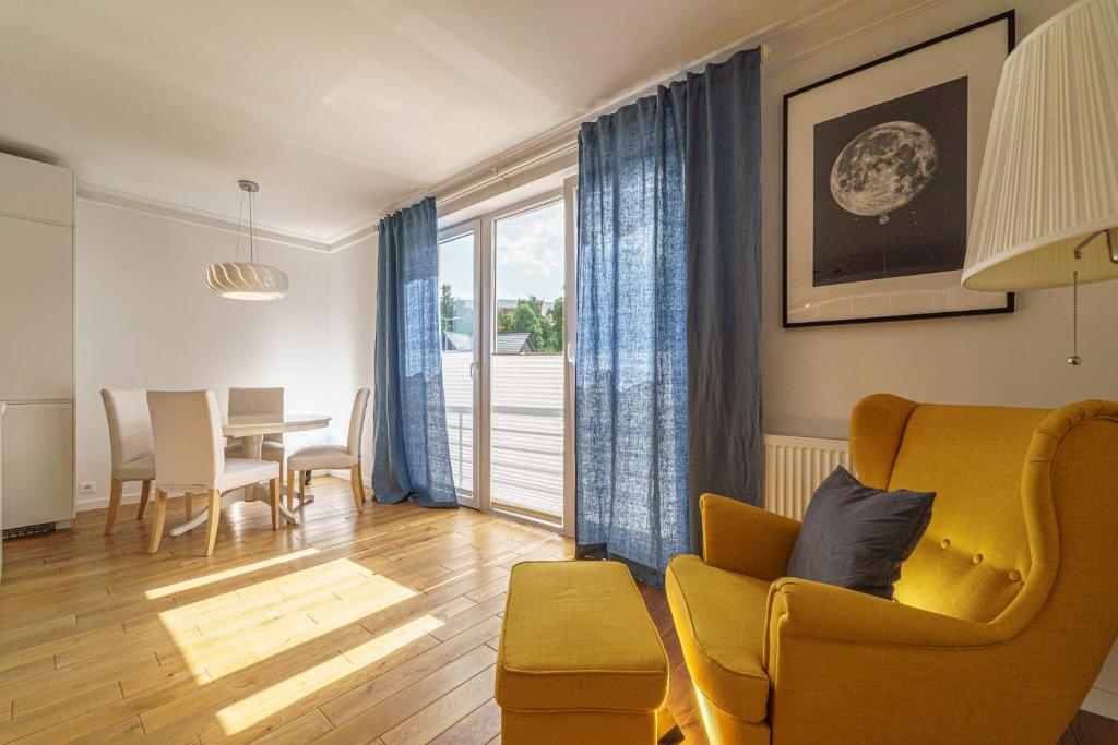 - un salon avec un canapé jaune et une table dans l'établissement Apartament Delux Mountain Aparts, à Świeradów-Zdrój