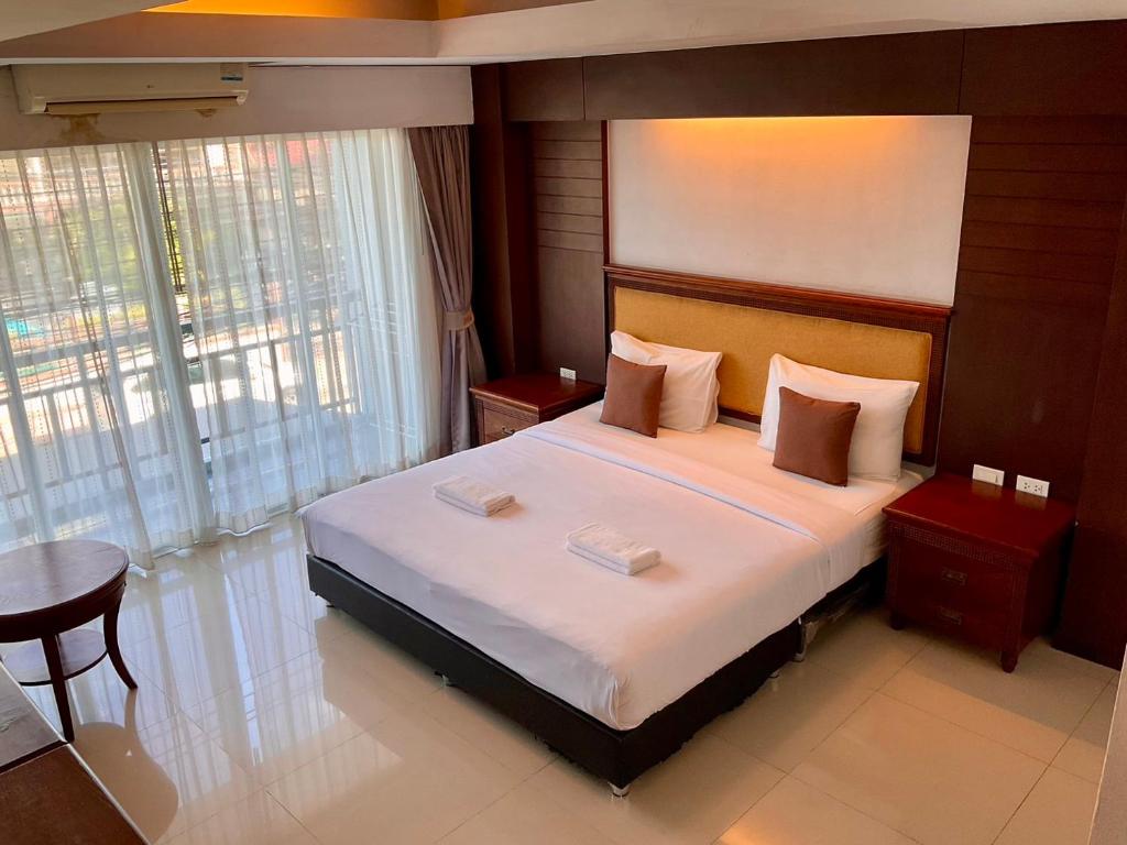 a bedroom with a large bed and a table and chairs at Sota Residence in Pattaya South