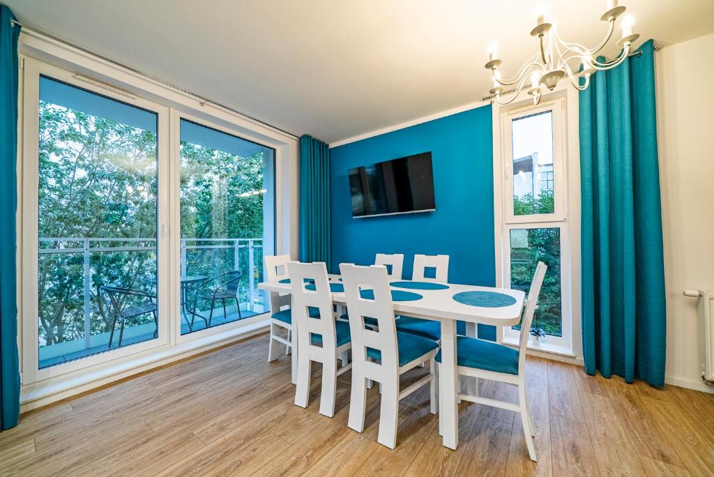 uma sala de jantar com mesa, cadeiras e janelas em Apartament Ali-Leo em Gdynia