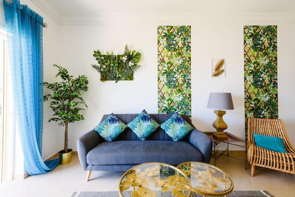 sala de estar con sofá azul y 2 mesas en Algarve Luxury Apartment in Boavista Golf Resort, en Lagos