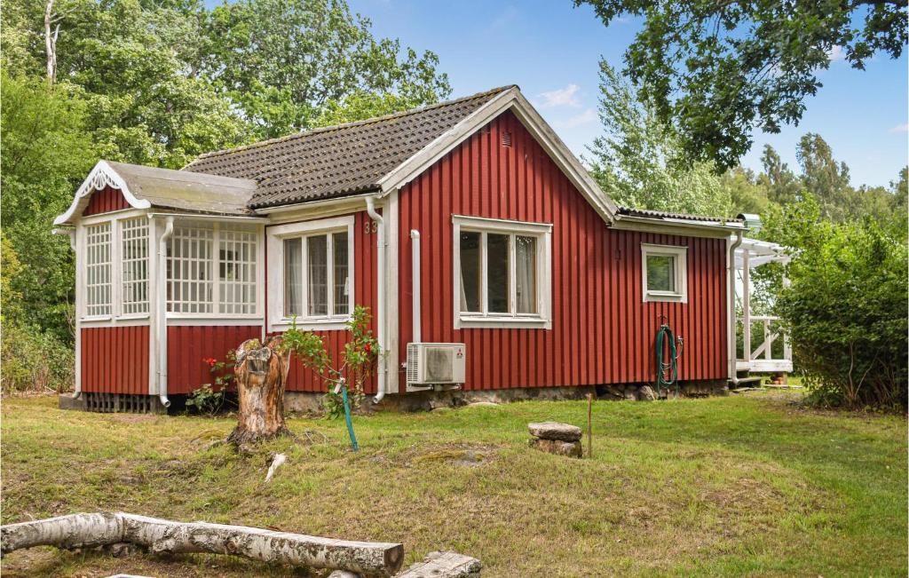 una casa rossa in un giardino con un albero di Gorgeous Home In Ronneby With Kitchen a Ronneby