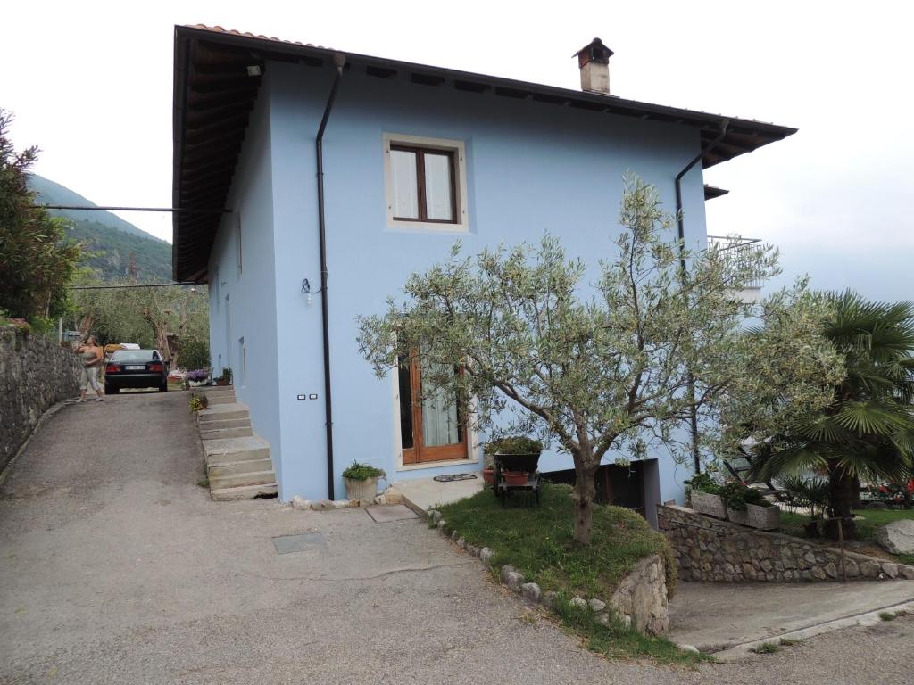 a blue house with a tree in front of it at Beggiato in Tenno