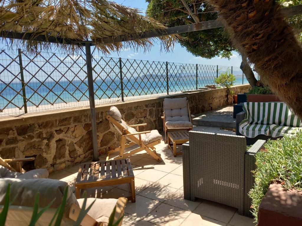 d'une terrasse avec des chaises et une vue sur l'océan. dans l'établissement Bed and Breakfast Onde Beach, à Su Forti