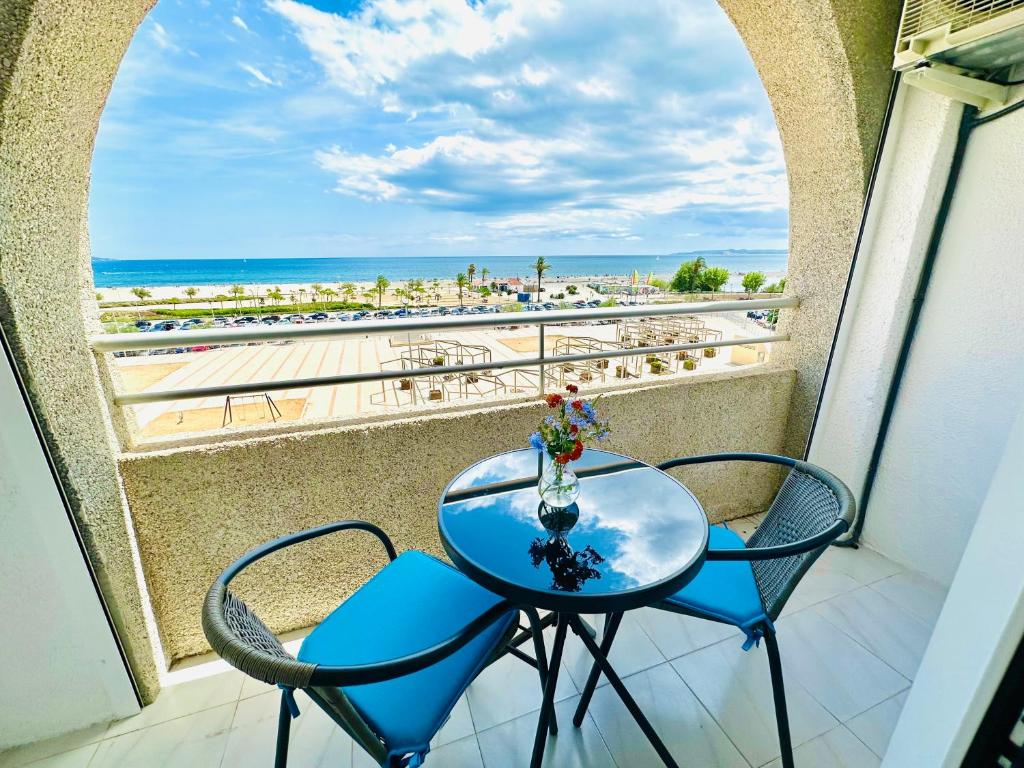 a table and chairs on a balcony with a view of the beach at Face a la Mer - vue epique, climatisation, wifi, draps inclus in Empuriabrava