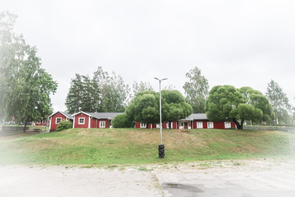 una luz de la calle en medio de un campo con casas en Skrå hostel - bed & business, en Släda