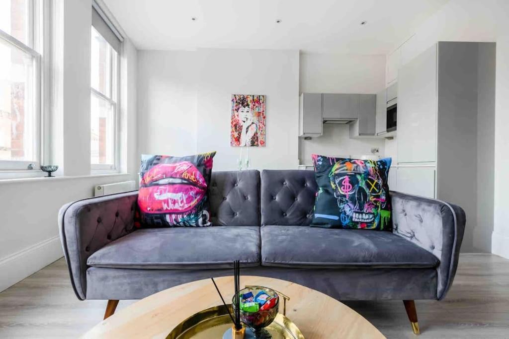 a purple couch in a living room with a table at Hampstead High Flyer in London