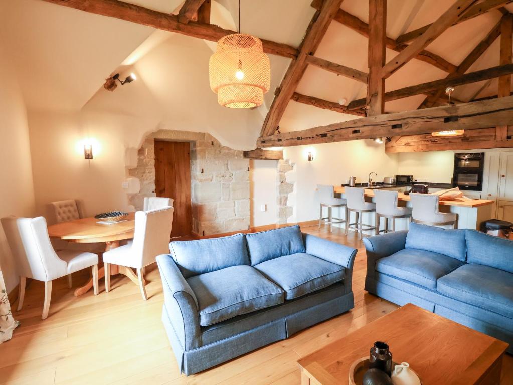 a living room with blue couches and a table at Tithe Barn in Derby