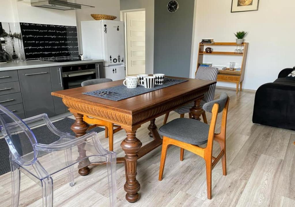 kuchnia z drewnianym stołem i krzesłami w obiekcie DolceVita - Gorzyce w mieście Gorzyce