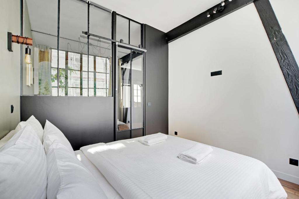 a bedroom with a white bed and a window at GemBnB Luxury Apartments - Sedaine in Paris